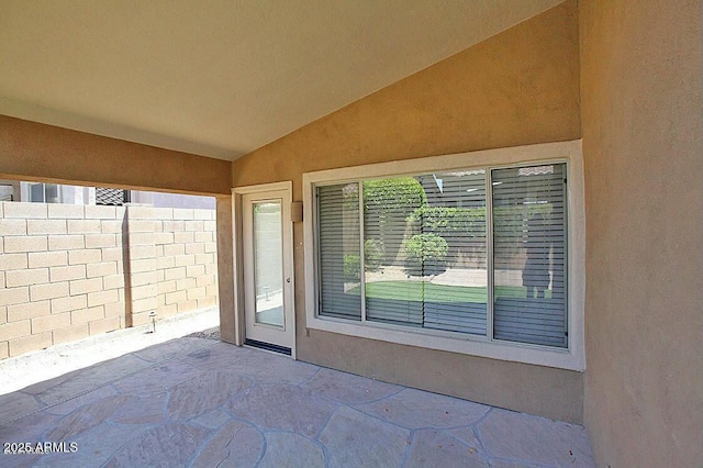 doorway to property with a patio area, fence, and stucco siding