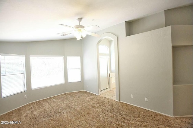 empty room with light carpet and a ceiling fan