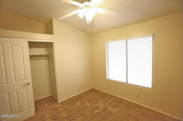 unfurnished bedroom with a closet, ceiling fan, carpet, and lofted ceiling