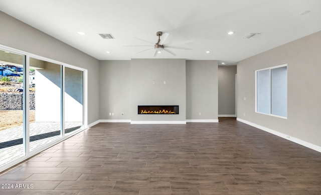 unfurnished living room with dark hardwood / wood-style floors and ceiling fan