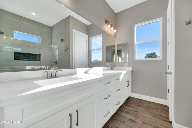 bathroom with vanity, a tile shower, and hardwood / wood-style floors