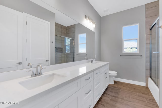 full bathroom with vanity, toilet, a healthy amount of sunlight, and hardwood / wood-style flooring