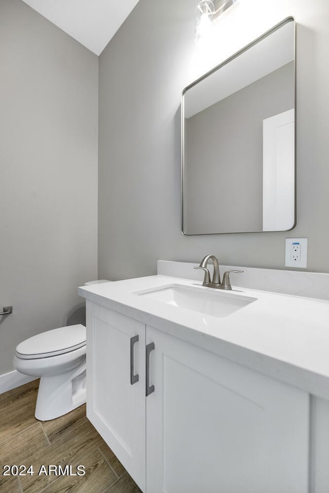 bathroom featuring vanity, hardwood / wood-style floors, and toilet