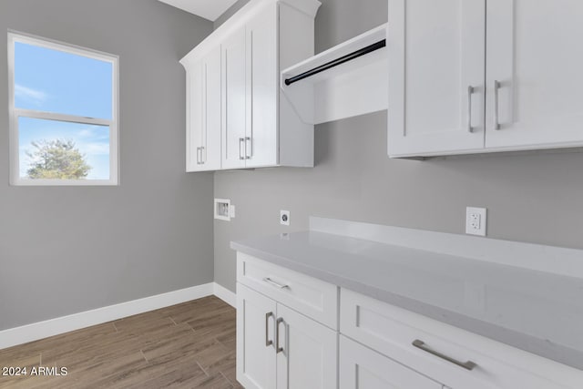 washroom with hookup for a washing machine, cabinets, hookup for an electric dryer, and hardwood / wood-style floors