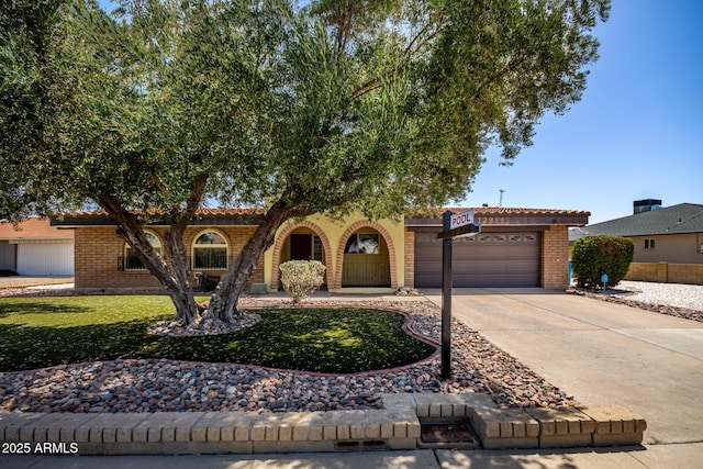 12811 N 44th Dr, Glendale, AZ 85304 - view of front of home with a garage, driveway, a tiled roof, and brick siding