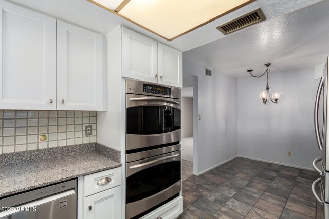 12811 N 44th Dr, Glendale, AZ 85304 - kitchen with stainless steel appliances, backsplash, white cabinets, and baseboards