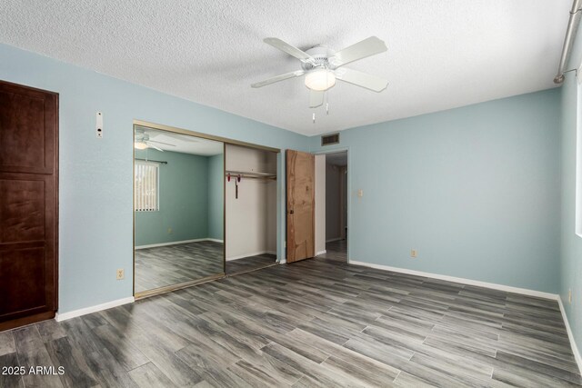12811 N 44th Dr, Glendale, AZ 85304 - unfurnished bedroom featuring wood finished floors, baseboards, a closet, and a textured ceiling