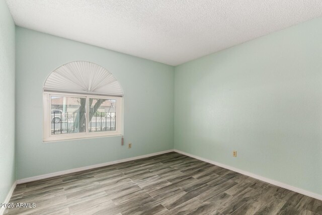12811 N 44th Dr, Glendale, AZ 85304 - spare room featuring wood finished floors, a textured ceiling, and baseboards