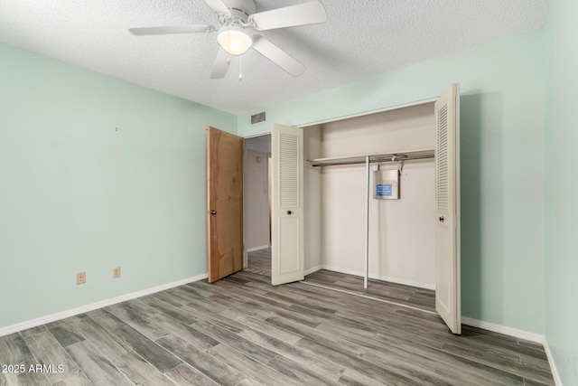 12811 N 44th Dr, Glendale, AZ 85304 - unfurnished bedroom with wood finished floors, a closet, a textured ceiling, and baseboards
