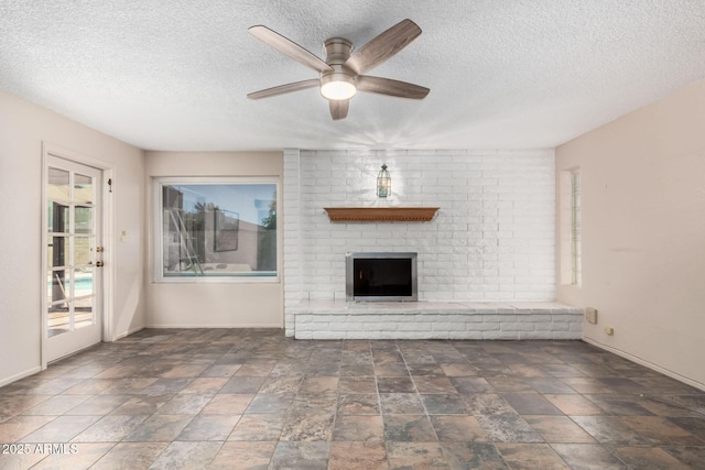 12811 N 44th Dr, Glendale, AZ 85304 - unfurnished living room featuring a textured ceiling, baseboards, ceiling fan, a fireplace, and stone finish floors