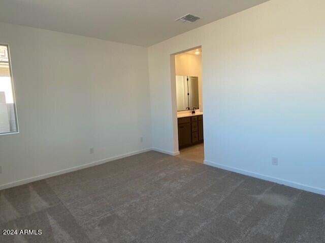 unfurnished room featuring dark carpet