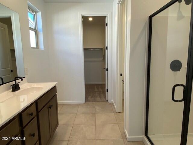 bathroom featuring vanity, tile patterned flooring, and an enclosed shower