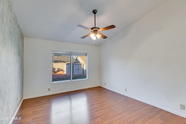 spare room featuring hardwood / wood-style floors, lofted ceiling, and ceiling fan