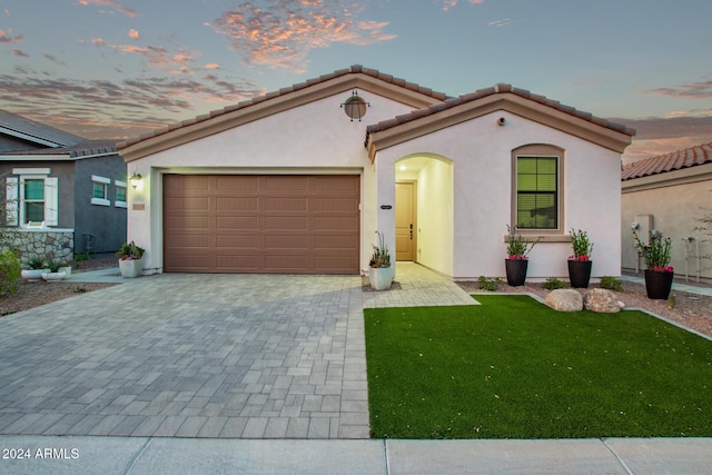 mediterranean / spanish-style house with a yard and a garage