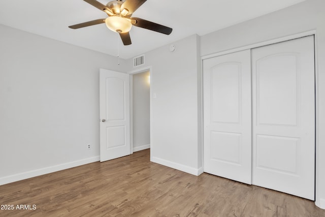 unfurnished bedroom featuring light wood-style floors, a closet, visible vents, and baseboards