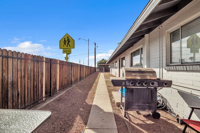 view of patio featuring a grill and fence