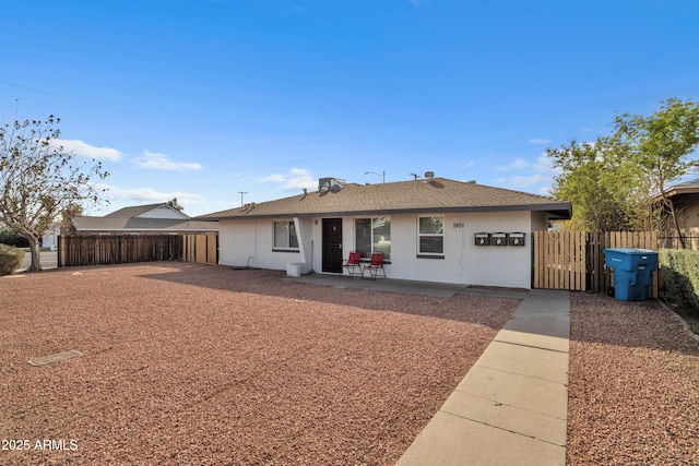 ranch-style house with a patio and fence