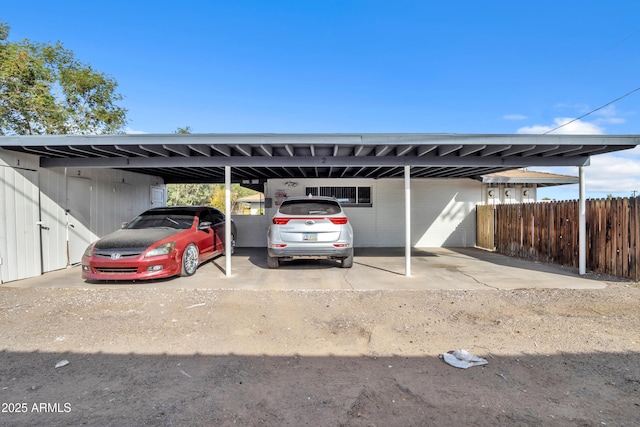 view of parking / parking lot with an attached carport and fence