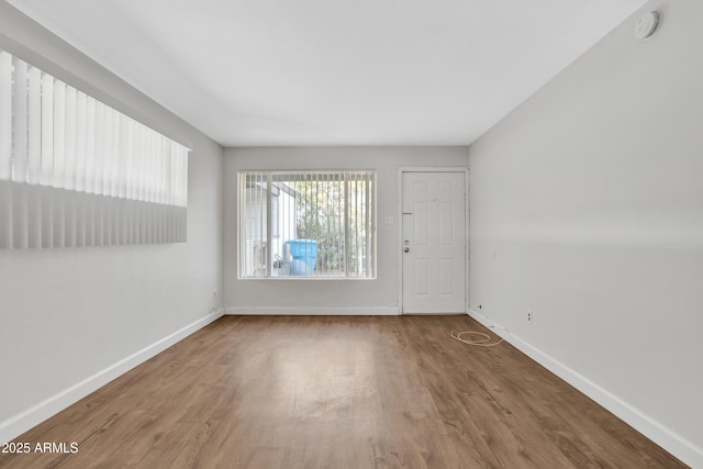 unfurnished room featuring baseboards and wood finished floors