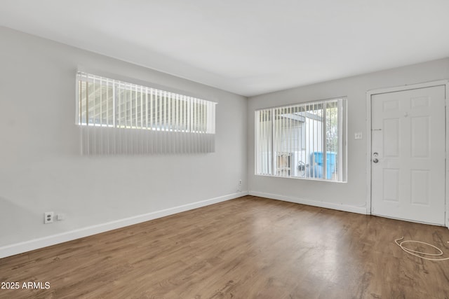 foyer featuring wood finished floors and baseboards