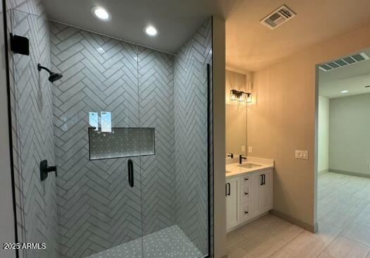 bathroom featuring recessed lighting, visible vents, a shower stall, vanity, and baseboards