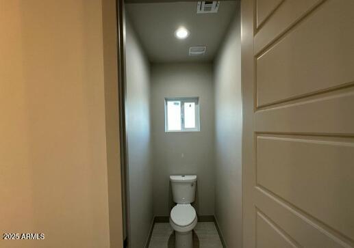 bathroom featuring visible vents, toilet, and baseboards