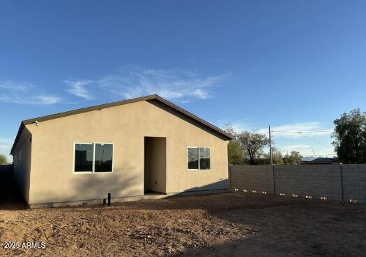 back of property with fence and stucco siding