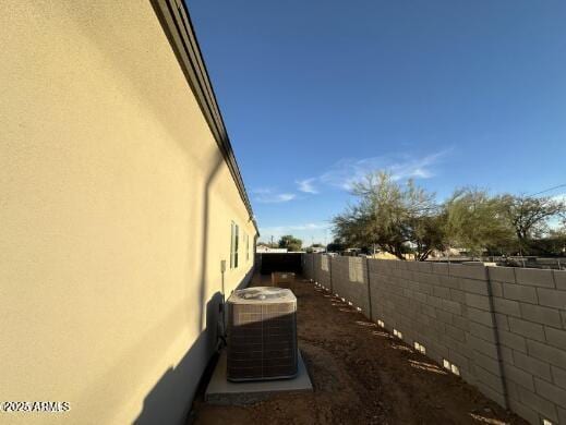 view of home's exterior with central air condition unit, a fenced backyard, and stucco siding