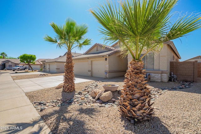ranch-style house featuring fence, stucco siding, an attached garage, driveway, and a tile roof