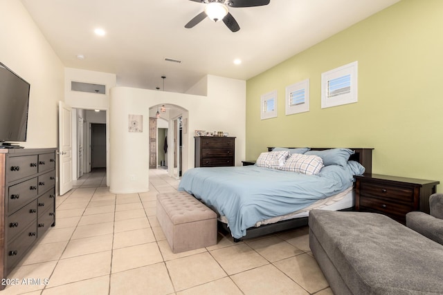 bedroom with light tile patterned floors, arched walkways, a ceiling fan, and visible vents