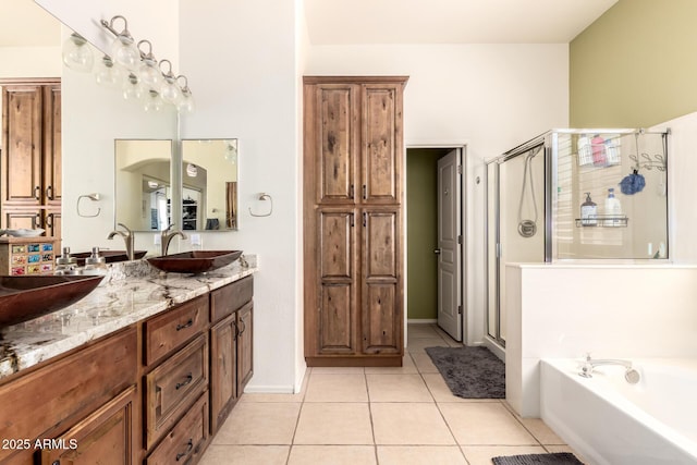 bathroom with tile patterned floors, a sink, a bath, and a stall shower