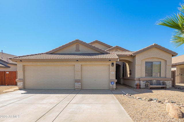view of front of property with an attached garage, driveway, stucco siding, and stone siding