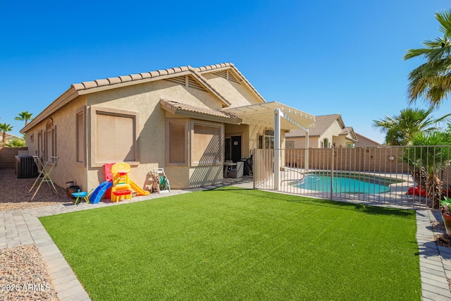 rear view of property with a yard, a pergola, a fenced backyard, and stucco siding