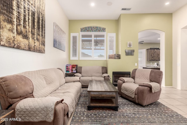 living room featuring tile patterned floors, a wealth of natural light, arched walkways, and visible vents