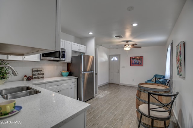 kitchen featuring white cabinetry, appliances with stainless steel finishes, sink, and light wood-type flooring