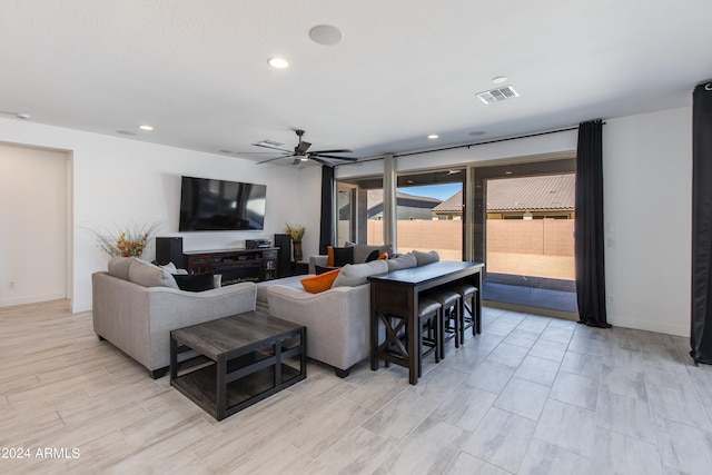 living room with ceiling fan and light hardwood / wood-style flooring