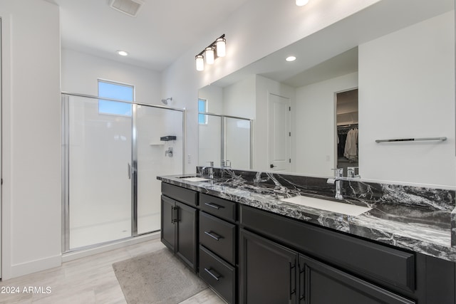 bathroom featuring wood-type flooring, vanity, and an enclosed shower