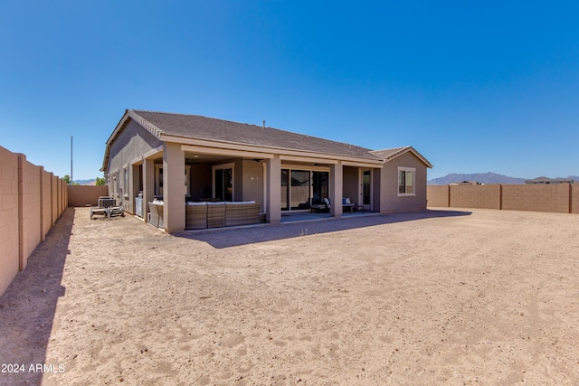 rear view of house with a patio and a mountain view