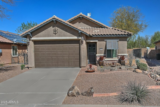 view of front facade with stucco siding, concrete driveway, an attached garage, a gate, and fence