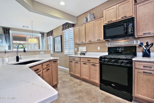 kitchen with a sink, visible vents, baseboards, light brown cabinetry, and black appliances