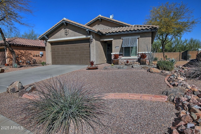 view of front of house featuring driveway, a tile roof, an attached garage, fence, and stucco siding