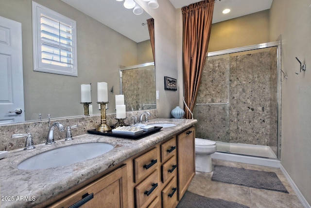 bathroom with double vanity, a shower stall, a sink, and tile patterned floors