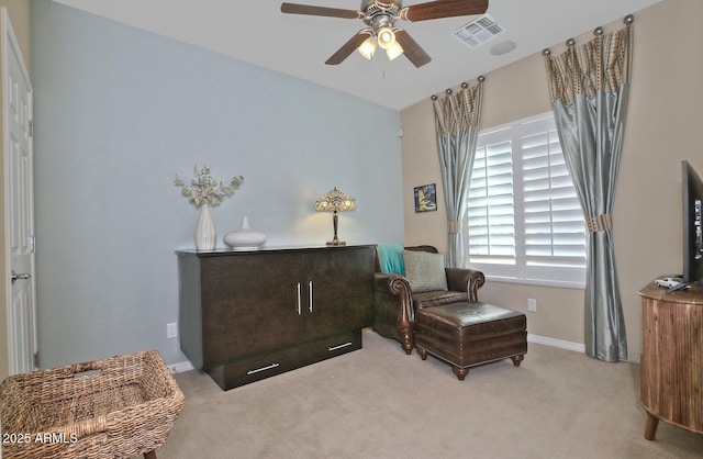 living area featuring carpet floors, baseboards, visible vents, and a ceiling fan