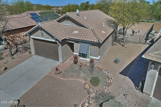 view of front of house with an attached garage, fence, a tile roof, concrete driveway, and stucco siding