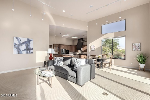 living room with a high ceiling and light carpet