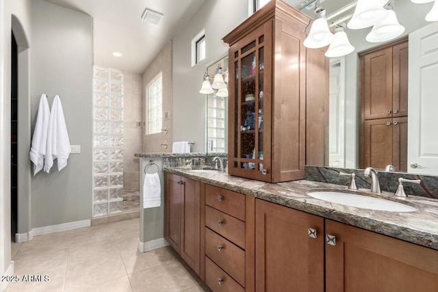 bathroom featuring vanity, tile patterned flooring, and a tile shower