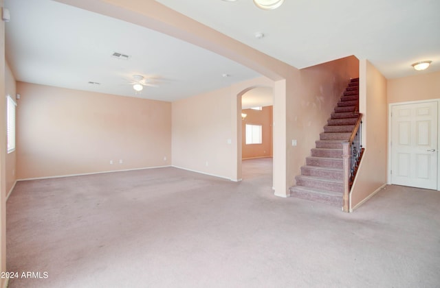 5659 S 239th Dr, Buckeye, AZ 85326 - unfurnished living room with light carpet, stairs, visible vents, ceiling fan, and arched walkways