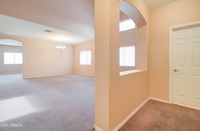 5659 S 239th Dr, Buckeye, AZ 85326 - entrance foyer with carpet floors, baseboards, arched walkways, and a healthy amount of sunlight