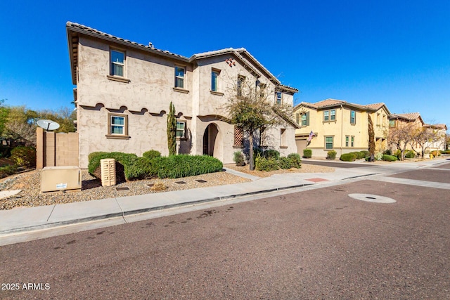 mediterranean / spanish house with a residential view and stucco siding