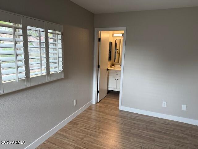 unfurnished bedroom featuring baseboards and wood finished floors